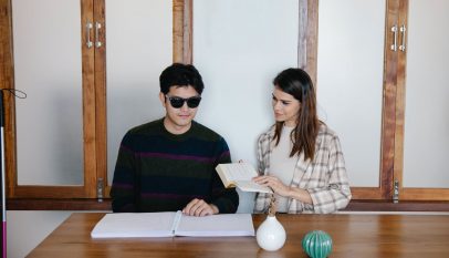 photo of people sitting together beside wooden table