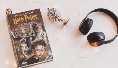 harry potter book and black headphones with trinket
