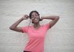 cheerful black woman with earphones dancing