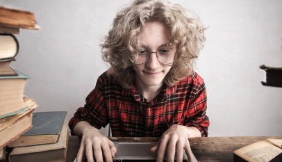 content young male student using laptop in library