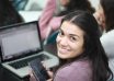 smiling woman in pink blazer using macbook pro