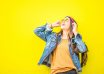 smiling woman looking upright standing against yellow wall