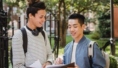cheerful multiethnic students sharing information about studies