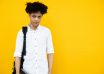 unemotional black man with backpack standing on yellow background
