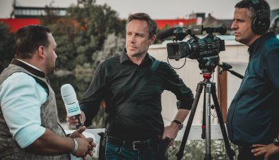 man holding microphone while talking to another man