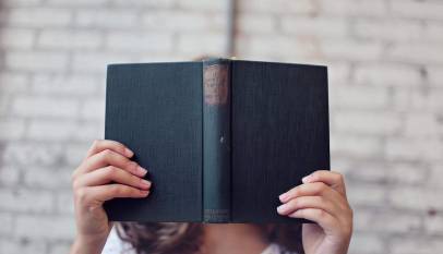 selective focus photography of woman holding book