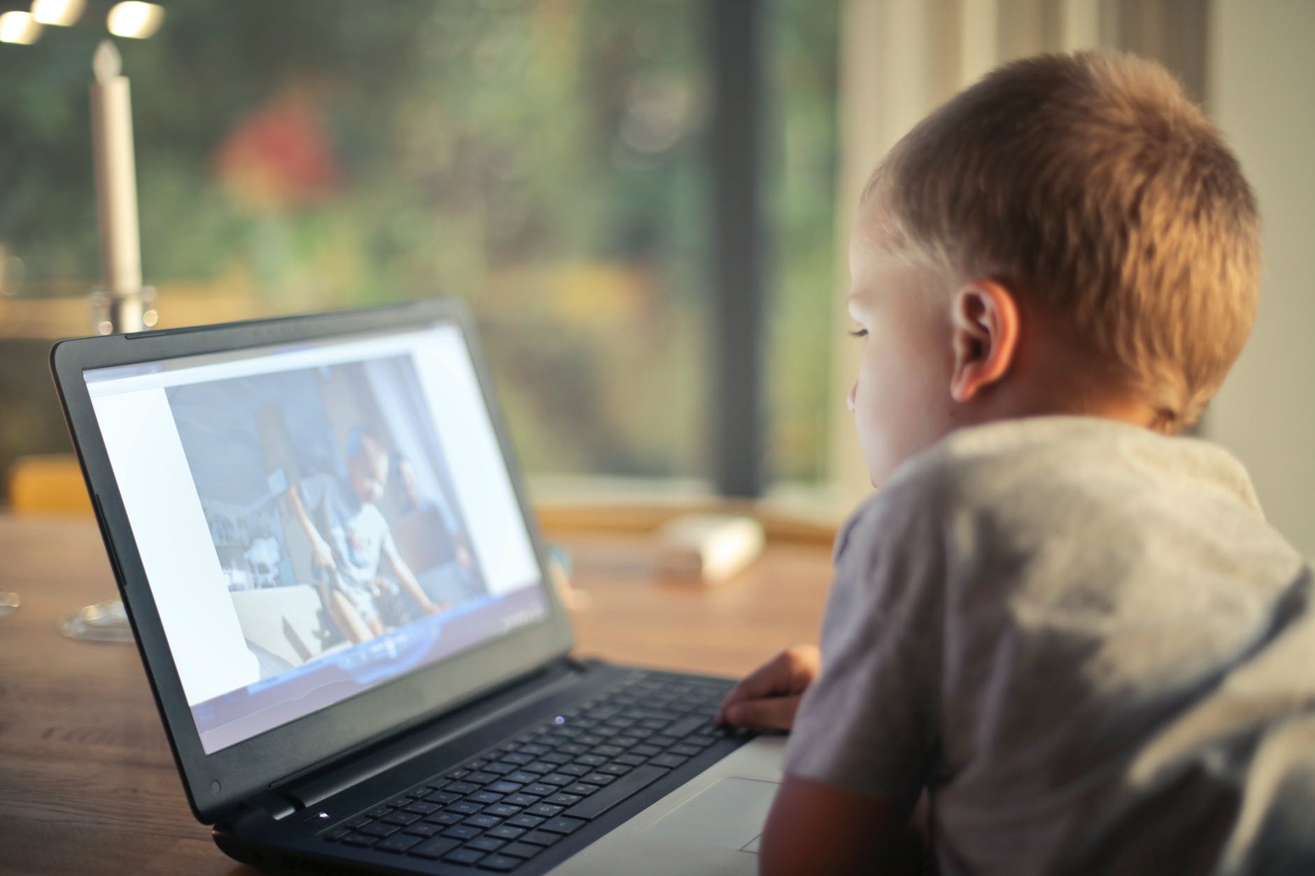 boy watching video using laptop