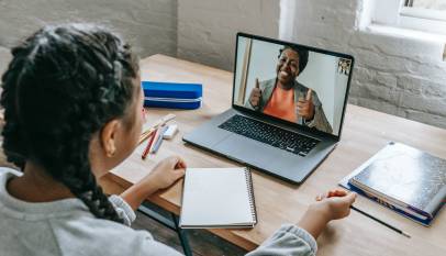 ethnic girl having video chat with teacher online on laptop