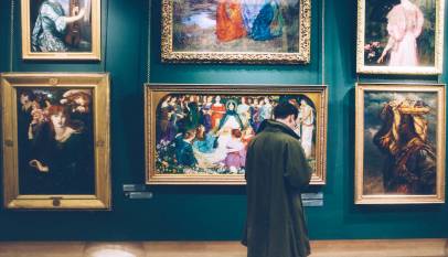 man standing in front of paintings
