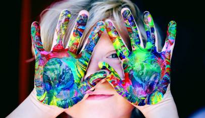 a kid with multicolored hand paint