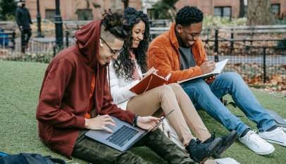 cheerful diverse classmates studying in park
